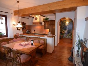 cocina y comedor con mesa de madera y sillas en Quaint Apartment in Zeil am Main with Terrace en Zeil