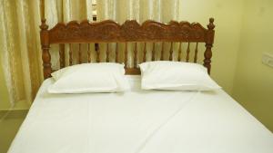 a bed with two white pillows on it at SS Family Villa in Varkala