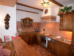 cocina con armarios de madera y encimera de madera en Quaint Apartment in Zeil am Main with Terrace en Zeil