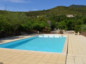 una grande piscina blu con montagne sullo sfondo di Captivating Holiday Home in Les Vans with Pool a Les Vans