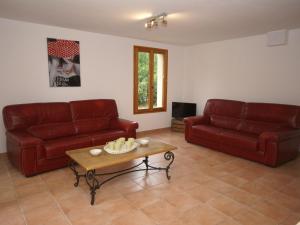 un soggiorno con 2 divani rossi e un tavolino da caffè di Captivating Holiday Home in Les Vans with Pool a Les Vans
