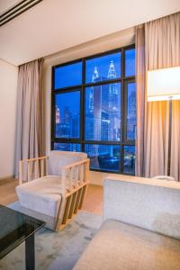sala de estar con ventana grande con vistas a la ciudad en 188 Suites KLCC by CoBNB, en Kuala Lumpur