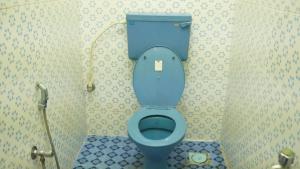 a bathroom with a blue toilet in a stall at SS Family Villa in Varkala