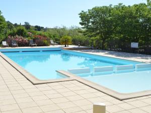 a large swimming pool with blue water at Captivating Holiday Home in Les Vans with Pool in Les Vans