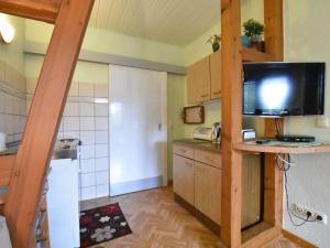 a small kitchen with a refrigerator and a television at Lovely Farmhouse in K hlungsborn near sea in Kühlungsborn