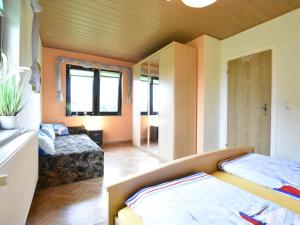 a bedroom with a bed and a couch in a room at Lovely Farmhouse in K hlungsborn near sea in Kühlungsborn