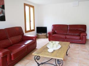 a living room with red leather couches and a coffee table at Captivating Holiday Home in Les Vans with Pool in Les Vans