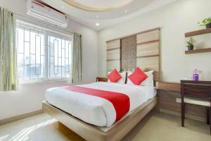 - une chambre avec un grand lit et un bureau dans l'établissement OYO OYO Emara Boutique Hotel Nearby Koramangala Forum Mall, à Bangalore