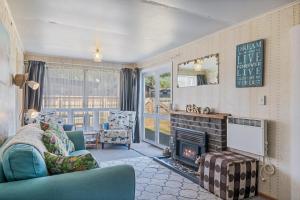 - un salon avec un canapé et une cheminée dans l'établissement Witsend - Foxton Beach Holiday Home, à Foxton Beach