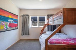 a bedroom with a bunk bed and a painting at Witsend - Foxton Beach Holiday Home in Foxton Beach