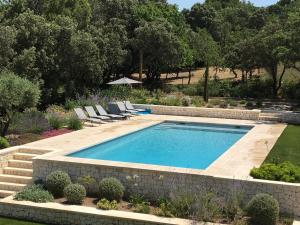 EyraguesにあるBeautiful villa with pool near St Remy de Provenceのラウンジチェア付きの庭園内のスイミングプールを利用できます。