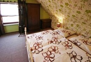 a bedroom with a bed with a floral bedspread at Lod - "Berliner Stube" in Kolpinsee