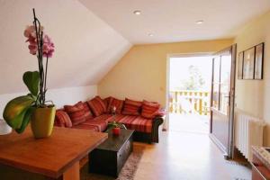 a living room with a red couch and a table at Lod - "Berliner Stube" in Kolpinsee +2 photos