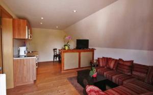 a living room with a couch and a kitchen at Lod - "Berliner Stube" in Kolpinsee