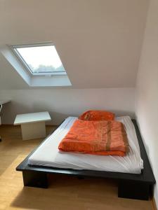 uma cama num quarto com uma janela em Schönes Dachapartment (2 Schlafzimmer) em Gütersloh