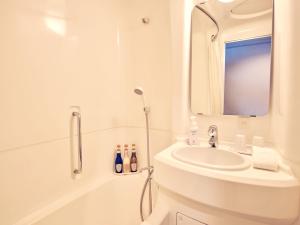 a white bathroom with a sink and a shower at Shinjuku Prince Hotel in Tokyo