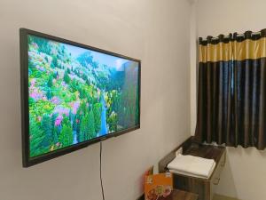 telewizor z płaskim ekranem wiszący na ścianie w obiekcie HOTEL SHYAM PALACE INDIA AGRA w mieście Agra