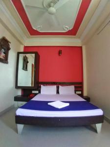 a bedroom with a large bed with a red wall at Panna Palace Guest House in Udaipur