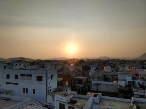 a view of a city with the sunset in the background at Panna Palace Guest House in Udaipur
