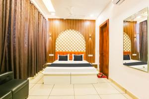 Schlafzimmer mit einem Bett und einem Spiegel in der Unterkunft Quilon Residency in Alappuzha