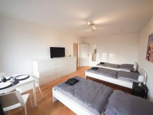 1 Schlafzimmer mit 2 Betten, einem Tisch und einem TV in der Unterkunft Nice Apartment in Bargteheide (Hamburg) in Bargteheide