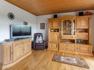 una sala de estar con un gran centro de entretenimiento de madera con TV de pantalla plana en Cozy Apartment in Sonnen Bavaria near Forest, en Sonnen