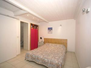 サンタ・ルシア・ディ・モリアニにあるHoliday Home in Poggio Mezzana near the beachのベッドルーム1室(ベッド1台、赤いカーテン付)