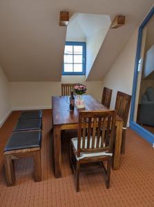 una sala da pranzo con tavolo e sedie in legno di Ferienwohnung Zur Kirschallee a Hochkirch