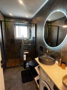 a bathroom with a shower and a sink and a mirror at Apartmán Artemis in Košice