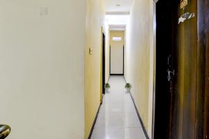 um corredor com duas plantas no meio de uma sala em SPOT ON Krishna Palace em Ujaim