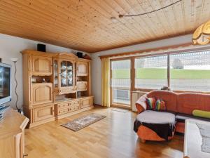 a living room with a couch and a large window at Cozy Apartment in Sonnen Bavaria near Forest in Sonnen
