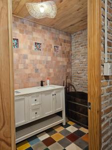 La salle de bains est pourvue d'un lavabo et d'un mur en briques. dans l'établissement Nhà Gạch cổ - Antique Brick House, à Bảo Lâm