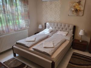 a bedroom with a bed with two towels on it at Jókai Apartman Szarvas in Szarvas