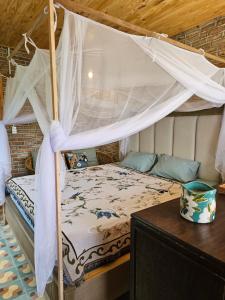 une chambre avec un lit à baldaquin dans l'établissement Nhà Gạch cổ - Antique Brick House, à Bảo Lâm