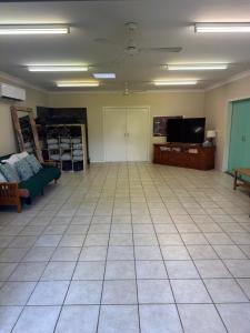 a room with a tiled floor with a couch and a tv at Gindabara Coochiemudlo Island in Coochiemudlo