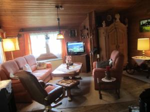 - un salon avec des canapés, une table et une télévision dans l'établissement Detached wooden house near Bad Wildungen, à Haina