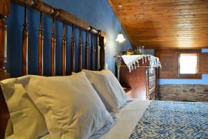 een slaapkamer met een bed met witte kussens bij Les Velles Escoles in Les Irles