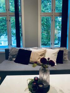 Una habitación con una cama con un jarrón con flores en una mesa en Mycondo no - Ø. Langgt 6, en Tønsberg