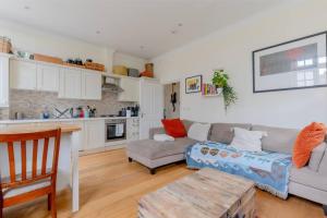 a living room with a couch and a table at Stylish Bohemian 2BD Flat Mile End Park! in London