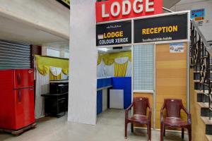 a store with two chairs and a sign for a lodge reception at OYO Century Park in Kāsaragod