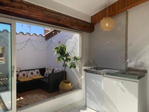 a kitchen with a window with a couch in it at Maison spacieuse et calme, idéal famille in Perpignan