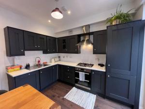 a kitchen with dark blue cabinets and a stove at Splendid South Dublin Ranelagh Townhouse in Dublin