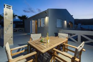 キサモスにあるZoe's Place - 1 BD Loft Beachfront Apartmentの家のあるパティオ(木製テーブル、椅子付)