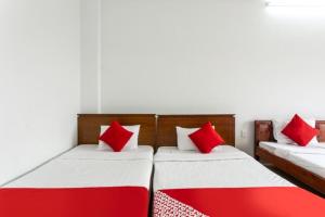 2 Betten in einem Zimmer mit roten und weißen Kissen in der Unterkunft Cửa Đại Beach Hotel in Hoi An