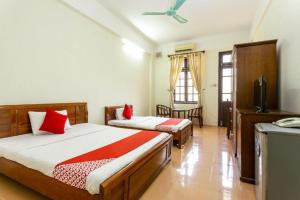 a bedroom with two beds and a television in it at Cửa Đại Beach Hotel in Hoi An