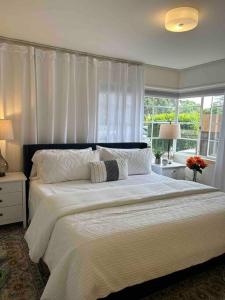 um quarto com uma grande cama branca e uma janela em Darling, Peaceful, Near Beach, EV Charger em Santa Bárbara
