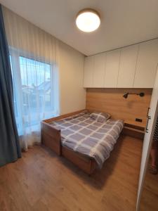 1 dormitorio con cama y ventana grande en Žvėrynas Workation apartments, en Vilna