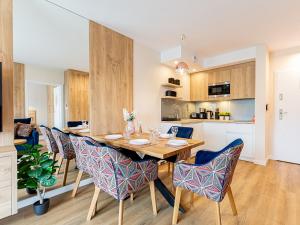 a kitchen and dining room with a wooden table and chairs at VacationClub - Apartamenty Zakopiańskie Apartament 344 in Zakopane