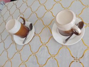 two cups of coffee sitting on saucers on a table at Olivers Binucot-Beach-House in Ferrol