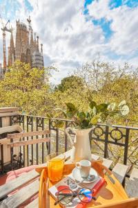 a wooden table with a drink and a vase on it at BBarcelona Sagrada Familia Garden Apartment in Barcelona